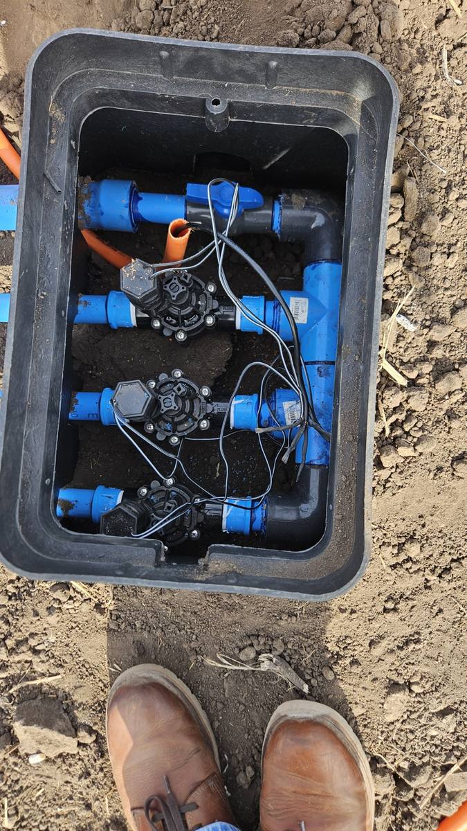 Detalle de electroválvulas y solenoides dentro de una cámara de riego automático