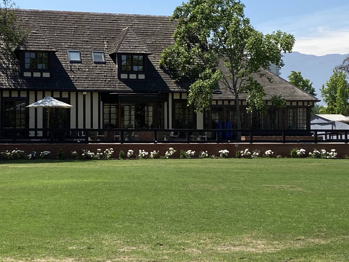 Cancha de polo y casona del Club de Polo y Equitación San Cristóbal, con el pasto recién cortado
