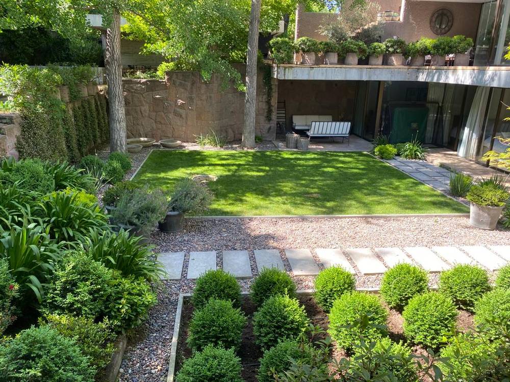 Jardín de casa particular diseñado por CV Paisajismo, con boj, gravilla y pasto