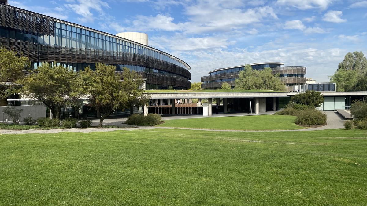 Pradera y arbolado frente a un edificio de oficinas en Vitacura