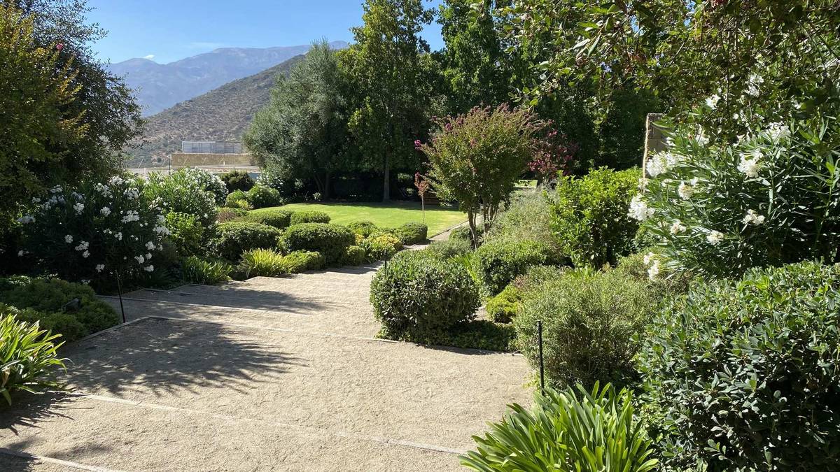 Áreas verdes de un condominio en Lo Barnechea mantenidas por CV Paisajismo, con la cordillera de fondo