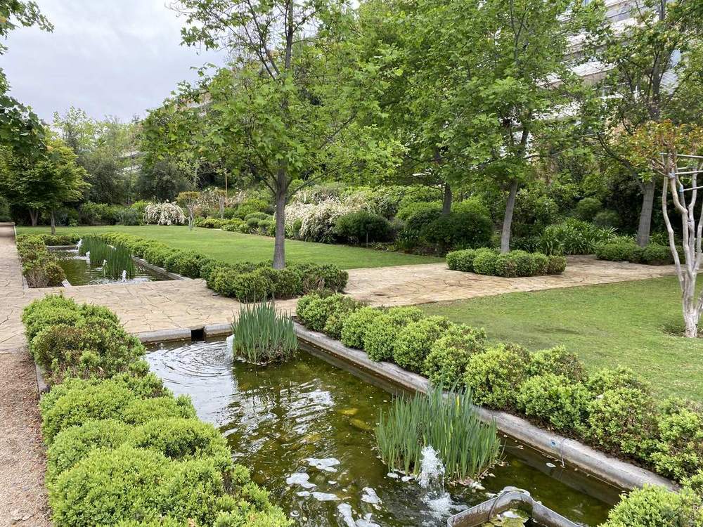 Jardín con espejo de agua en las áreas comunes de un condominio de Lo Barnechea