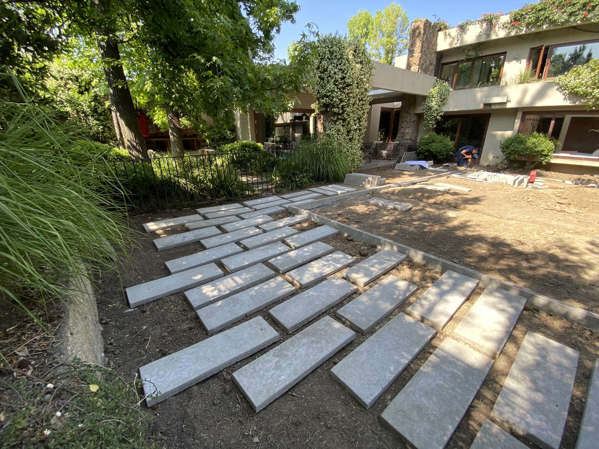 Instalación de pastelones de hormigón sobre tierra durante la construcción del jardín